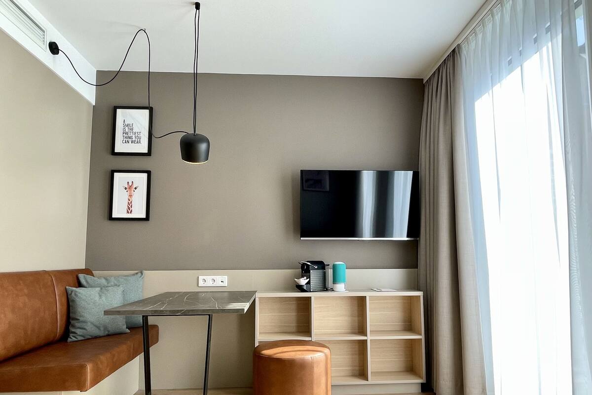 Een moderne woonkamer met een bank, een salontafel, een televisie en een boekenkast.