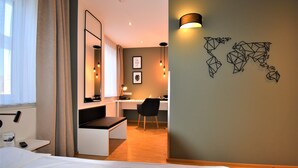 Una habitación de hotel con cama, escritorio, silla y mapa colgado en la pared.