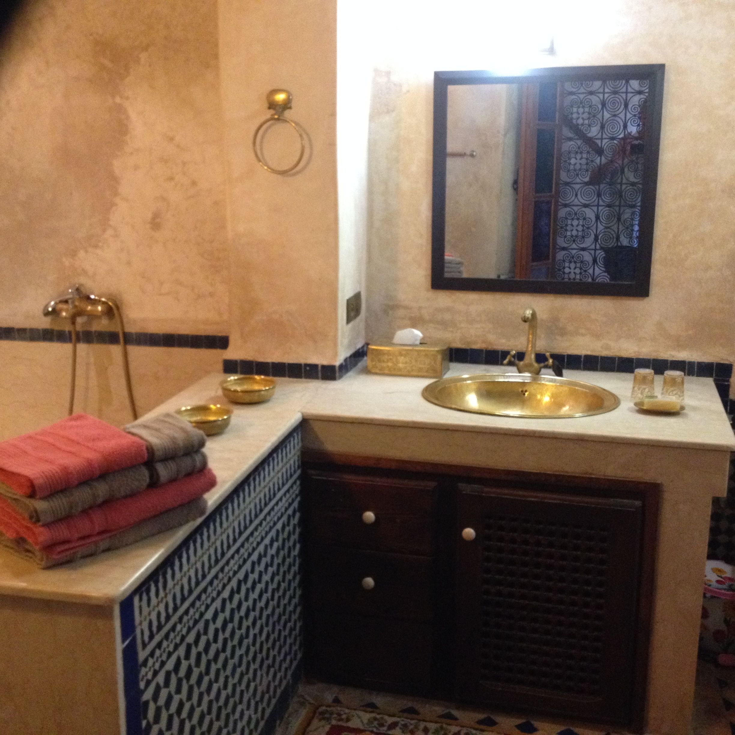A bathroom with a sink, mirror, and towel rack.