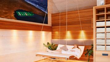 Relax in a serene space with a massage chair, towels, and a beautiful painting.
