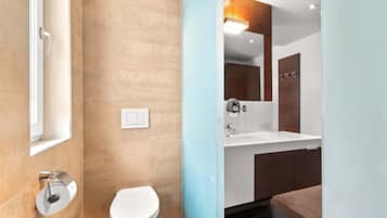 Un bagno moderno con toilette, lavandino e specchio.
