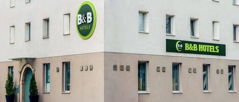 Ein Bed & Breakfast Hotel mit moderner Fassade, zahlreichen Fenstern und einem grünen Schild.