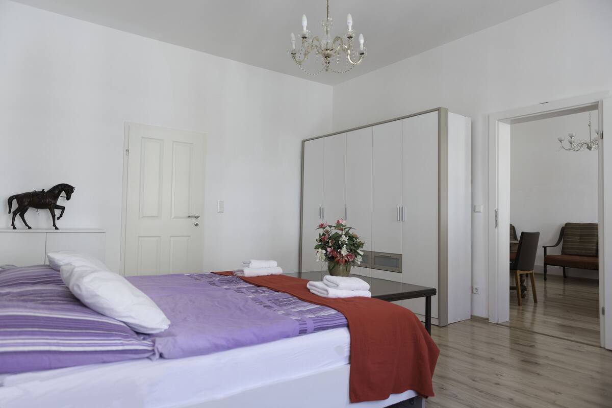 Un dormitorio con cama, cómoda, silla y mesa de comedor.