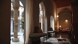 An interior with a bench, a sofa, and a patterned rug.
