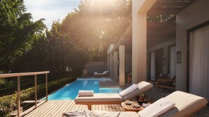 A poolside area with lounge chairs, a wooden deck, and a clear view of the pool. - Delaire Graff Lodges & Spa (Stellenbosch)