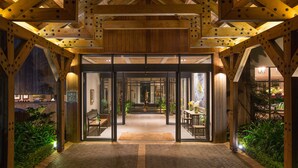 A wooden structure with a glass entrance, a bench, and a table with flowers. - Delaire Graff Lodges & Spa (Stellenbosch)