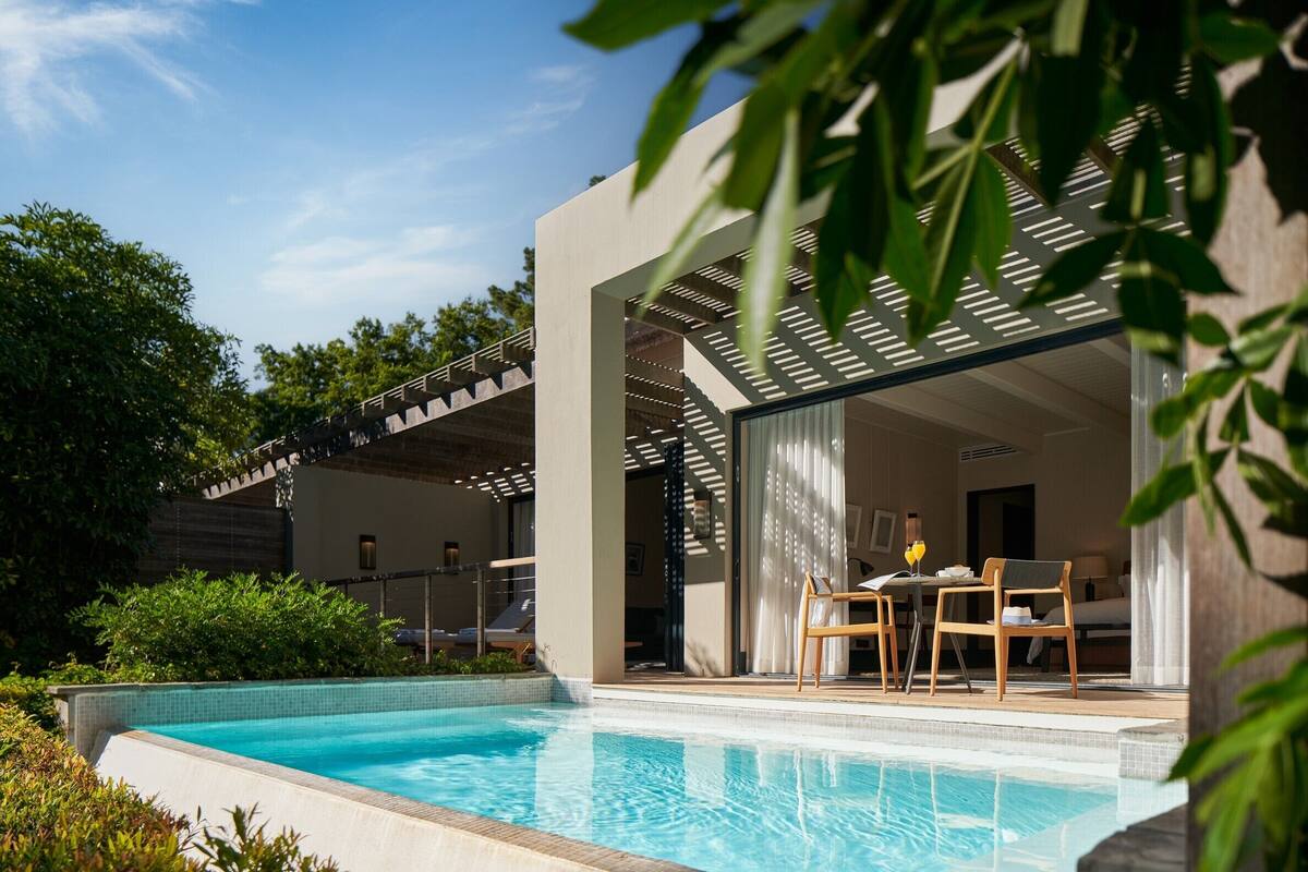 Um hotel moderno com piscina, área de estar ao ar livre e um terraço coberto.