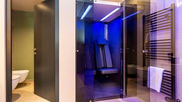 Bathroom features a shower area with a bench, toilet, sink, and towel rack.