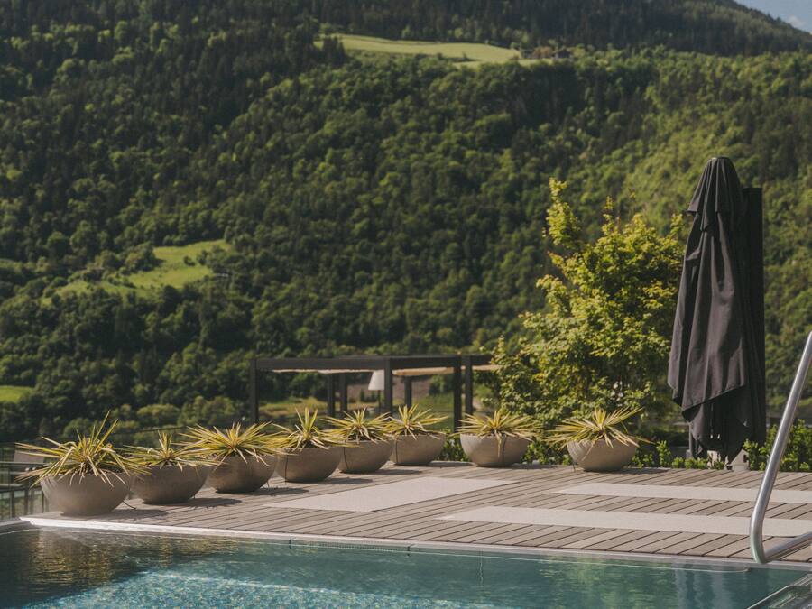 A pool area with a view of a forested mountain.