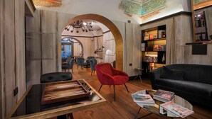 A modern living room with a wooden coffee table, a red armchair, and a black sofa. - Relais Orso (Rome)