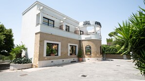 A modern hotel with a two-story structure, a central courtyard, and a prominent sign. - Cervara Park Hotel (Rome)