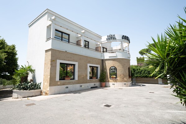 A modern hotel with a two-story structure, a central courtyard, and a prominent sign. - Cervara Park Hotel (Rome)