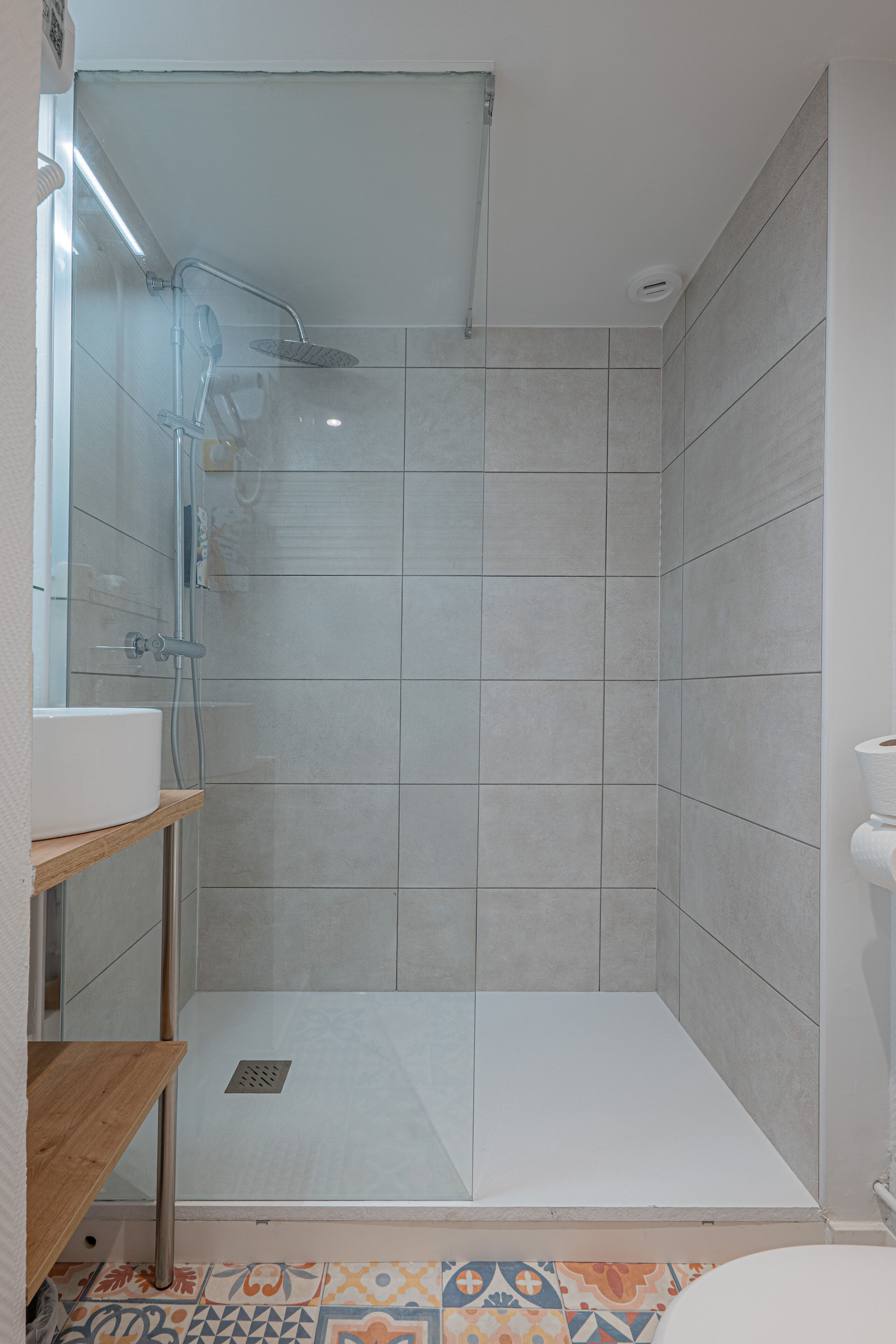 A shower with a glass door, a sink, and a toilet.