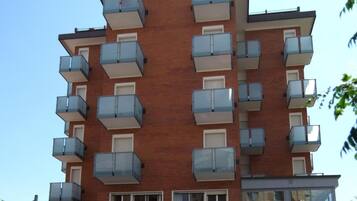 Un hotel moderno a più piani, con balconi su ogni piano e un cartello con la scritta 'Hotel Aesar'.