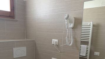 A bathroom with a toilet, sink, and a towel rack.