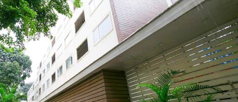 A multi-story building with a modern architectural design, featuring a mix of brick and wood paneling.