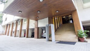 A building entrance with a wooden overhang, a staircase, and a parking garage. - The Roa (Mumbai)