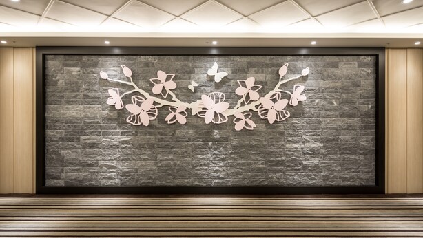 A wall with a floral design and a textured stone background. - Formosa Corridor Hotel (Taichung)