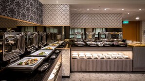 A buffet setup with multiple serving stations and a central display of plates. - Formosa Corridor Hotel (Taichung)