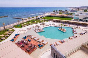 Una piscina al aire libre, sombrillas, sillones reclinables de piscina