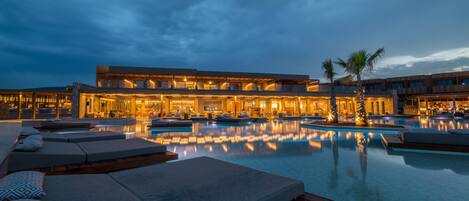 Alberca al aire libre, sombrillas en la alberca y camastros