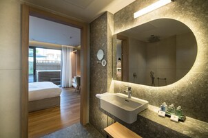 Un baño moderno con un espejo grande, un lavabo y un banco.
