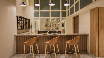 Una cocina moderna con barra, detalles de madera e iluminación colgante.
