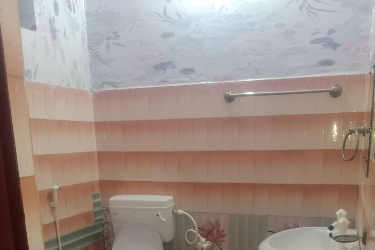 A bathroom with a toilet, sink, and shower.