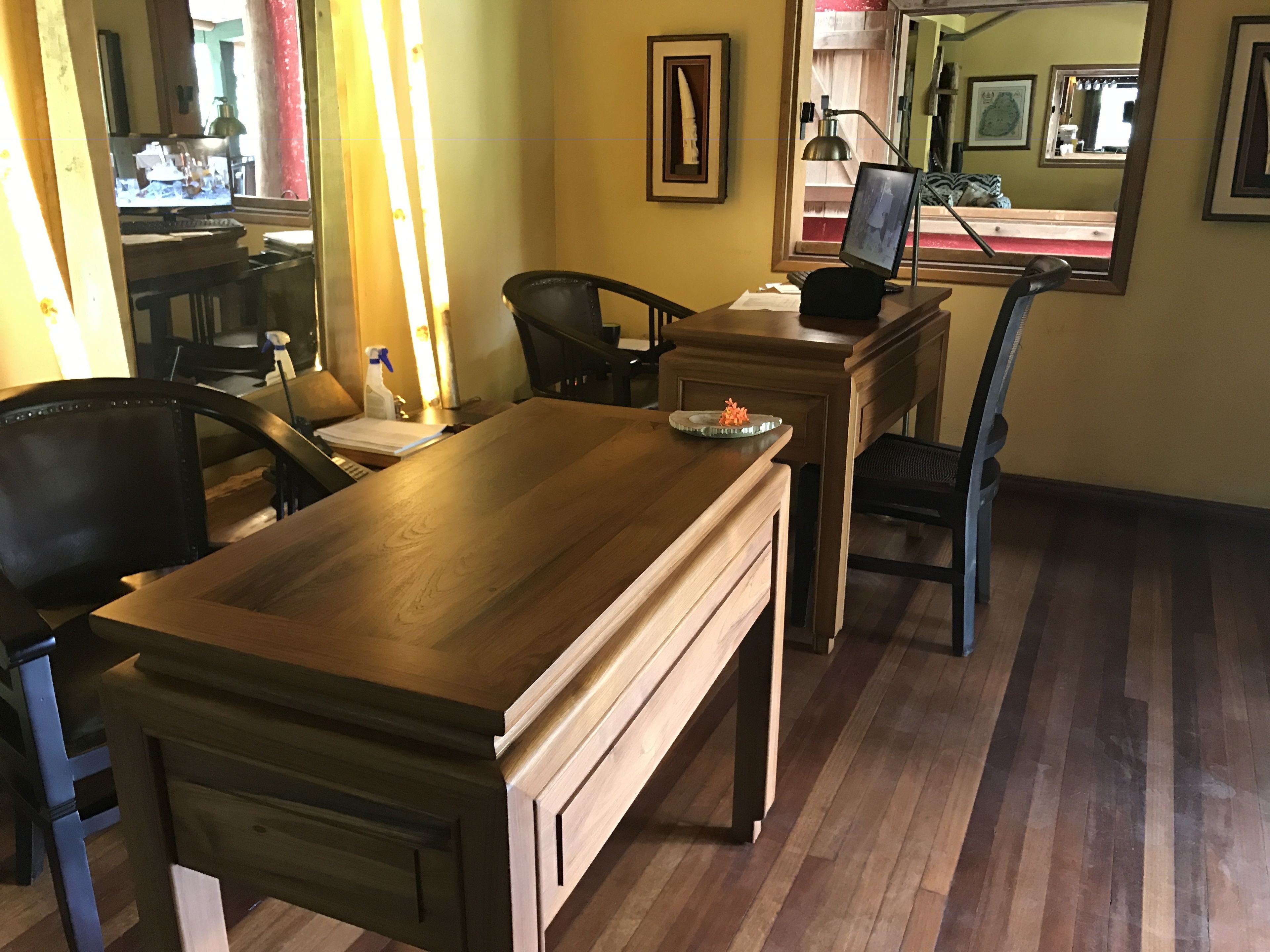 Un comedor con una mesa de madera, sillas y una mesita auxiliar con lámpara.