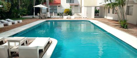 Una piscina al aire libre, sombrillas