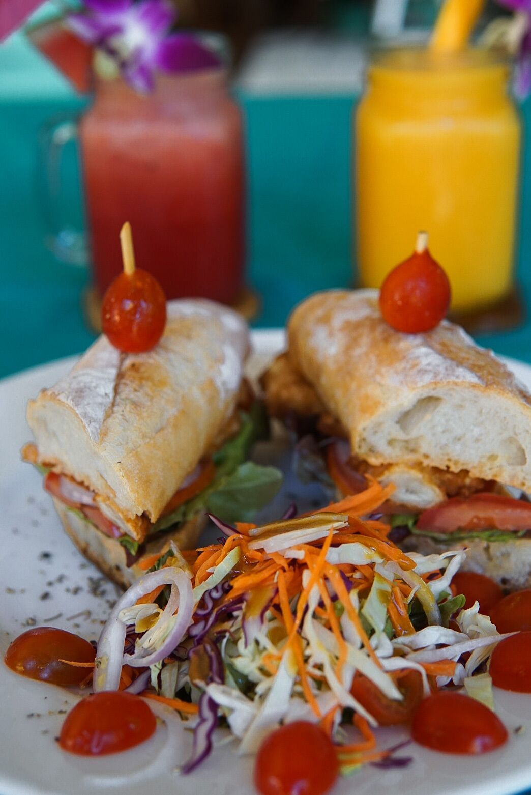 Un sándwich con ensalada de col y tomates cherry en un plato.