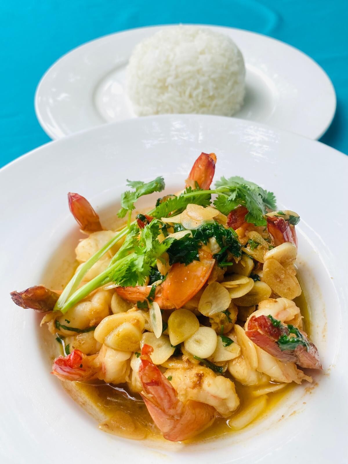 A plate of shrimp and vegetables with a side of white rice.