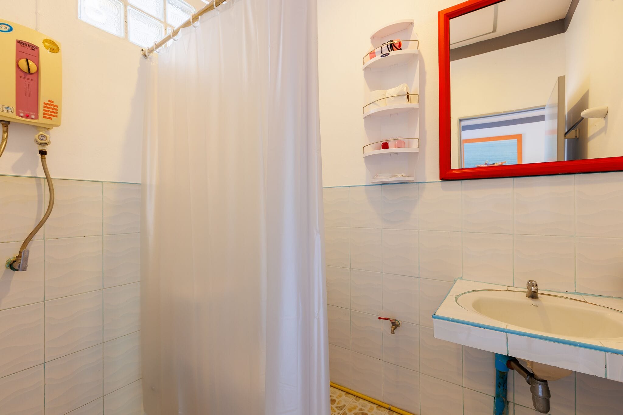 A bathroom with a shower, a sink, a mirror, and a towel rack.