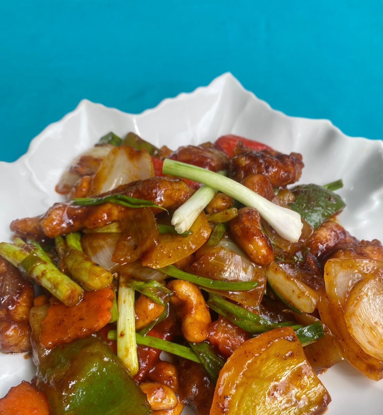 A dish of stir-fried vegetables and meat on a white plate.