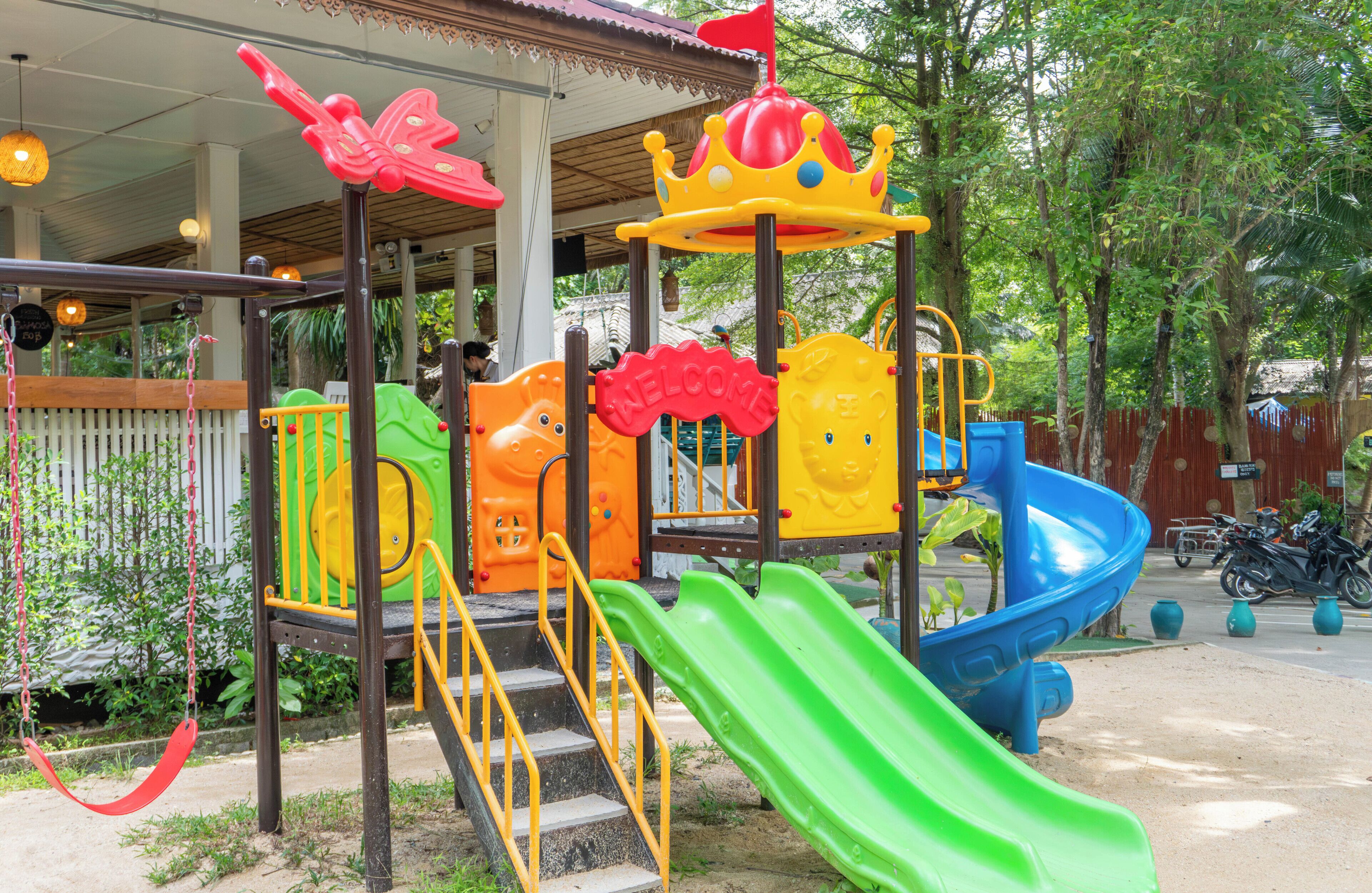 Ein Spielplatz mit Rutsche, Klettergerüsten und einer Zierkrone.
