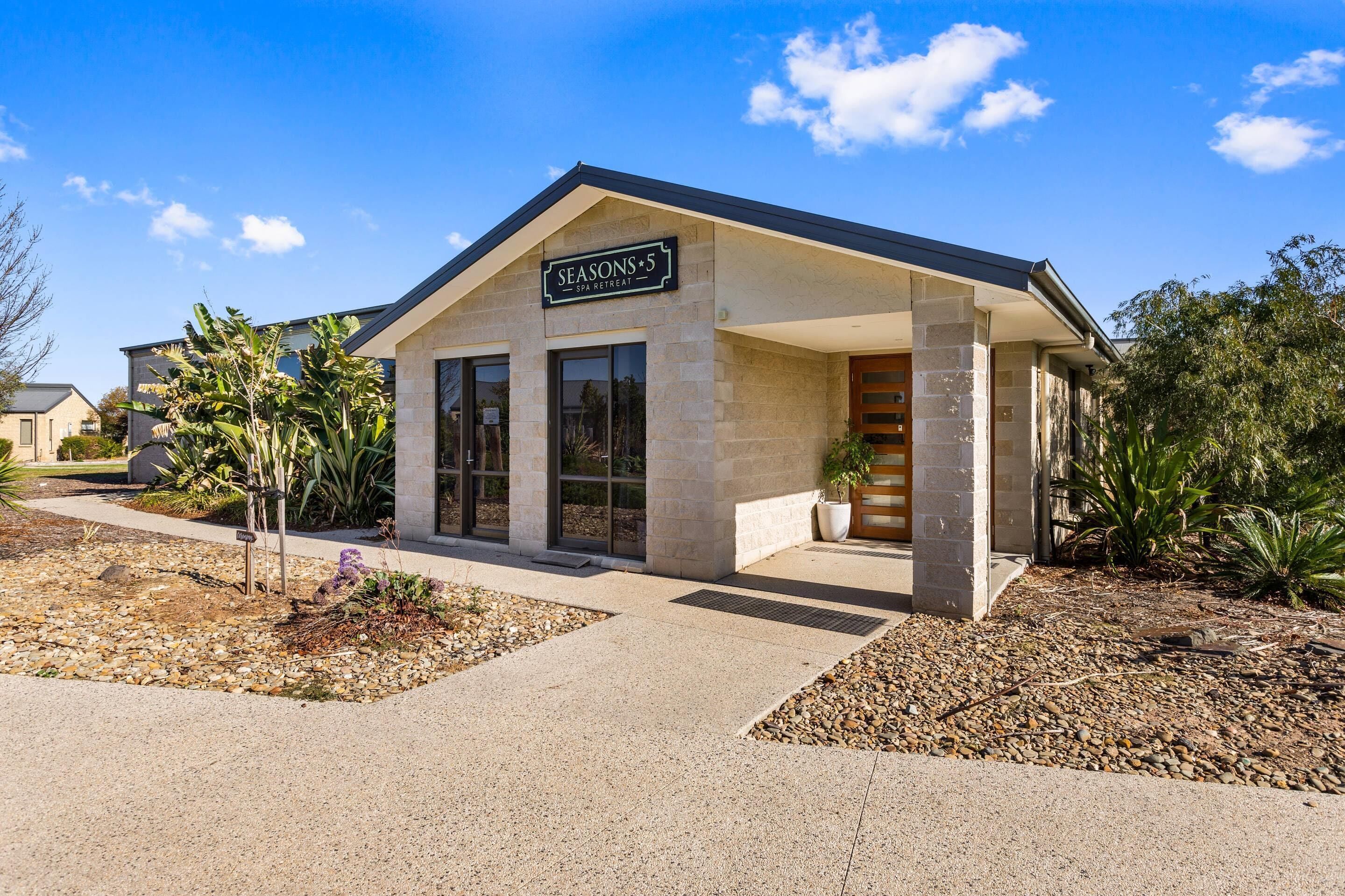 A building with a sign reading 'SEASONS 5 SPA RETREAT' and a covered entrance.