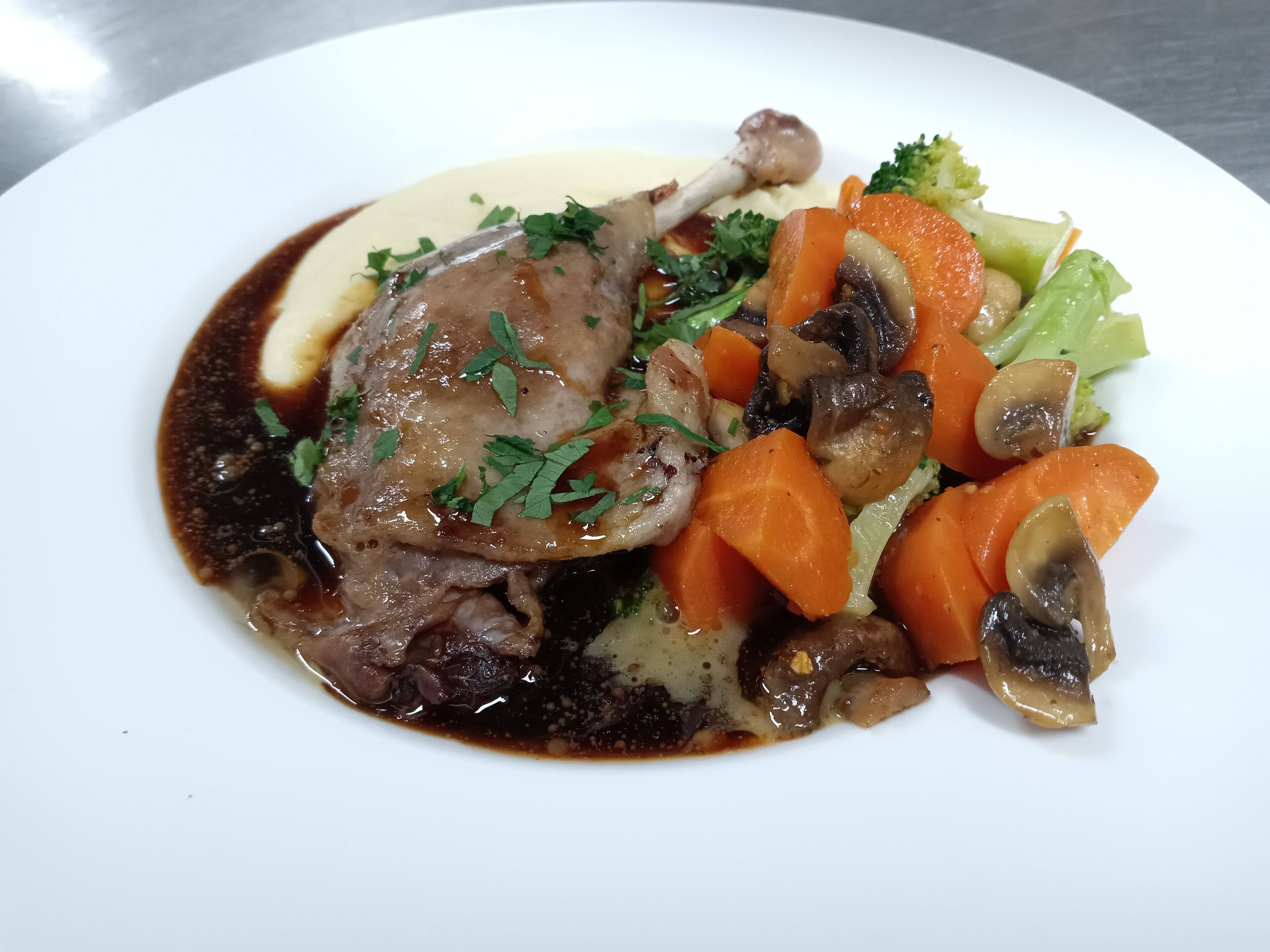 Une assiette contenant un plat composé d’une portion de viande, de légumes et d’une sauce.