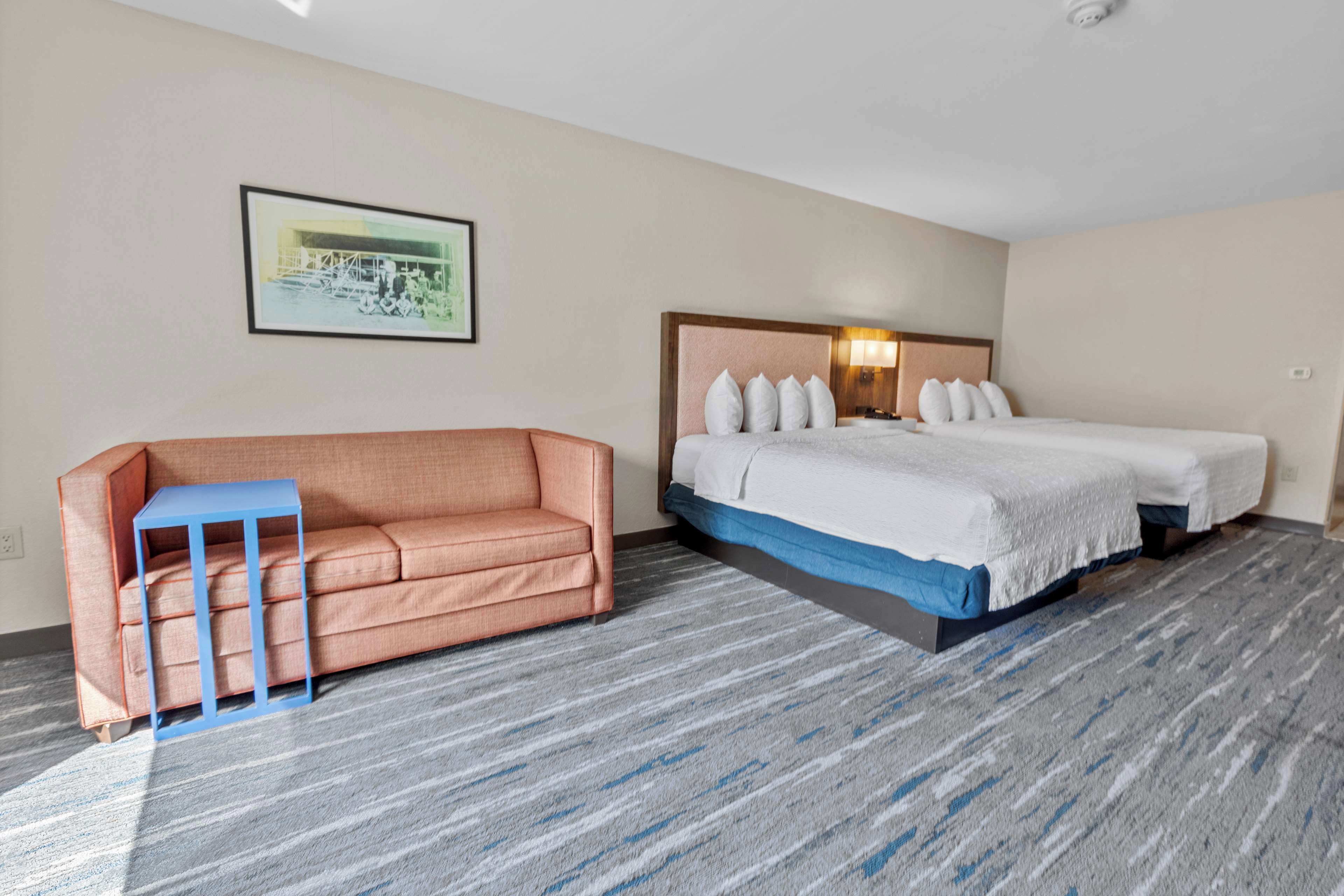 Une chambre d’hôtel avec un canapé, un lit et une petite table.