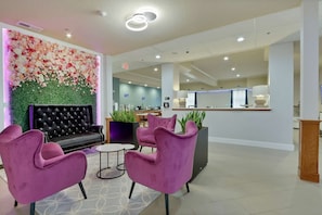 Relax in a stylish seating area with plush sofas and elegant flower arrangements.