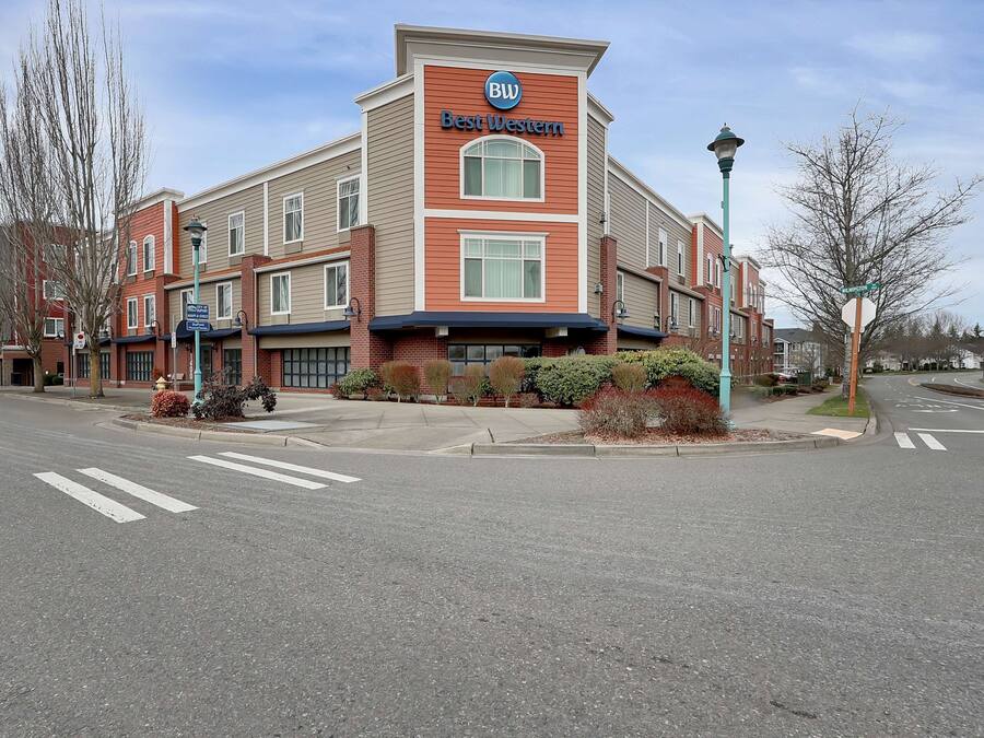 A Best Western hotel with a two-story facade, a parking lot, and a crosswalk.