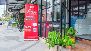 Fachada con un gran letrero rojo que anuncia la descarga gratuita de una aplicación para obtener un cupón de descuento del 100%.