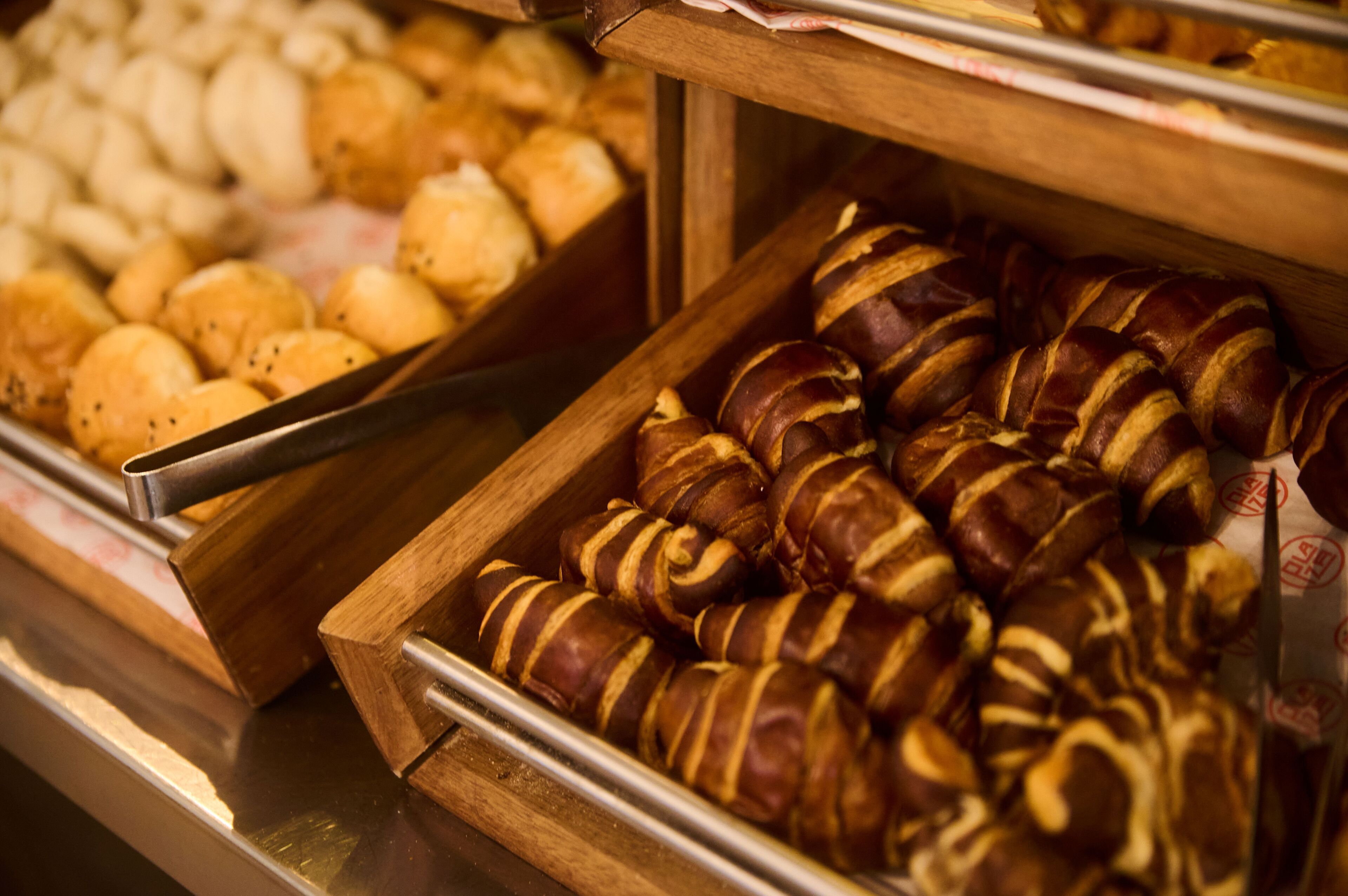 A bakery display with various baked goods, including croissants and other pastries.