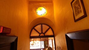 An arched doorway with a stained glass window and a round light fixture above it. - Hotel Touring (Messina)