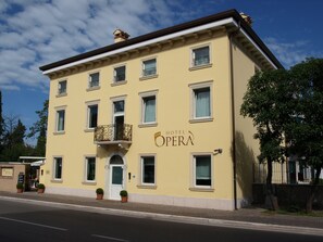 A yellow building with a sign reading "Hotel Opera".