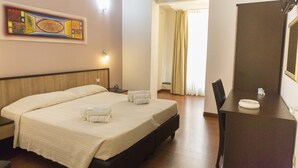 A hotel room with a large bed, a desk, and a mirror. - Lewisrooms Domo (Cagliari)