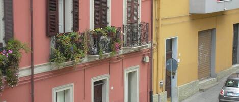 A row of buildings with balconies, some with plants.