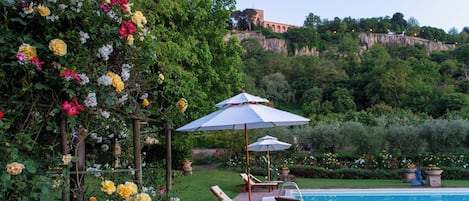 Una piscina al aire libre de temporada, sombrillas