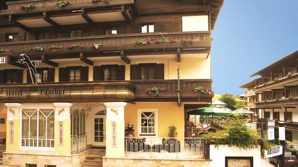 Um hotel com vários andares, varandas, área de recepção e café.