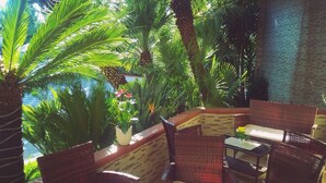 Un espace extérieur aménagé avec des meubles en osier et offrant une vue sur une piscine.