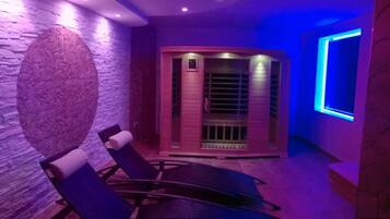 Relax in a serene space with a massage room, sauna, and comfortable seating area.